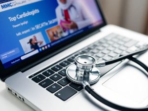 Laptop cu stetoscop pentru căutarea cardiologilor online.